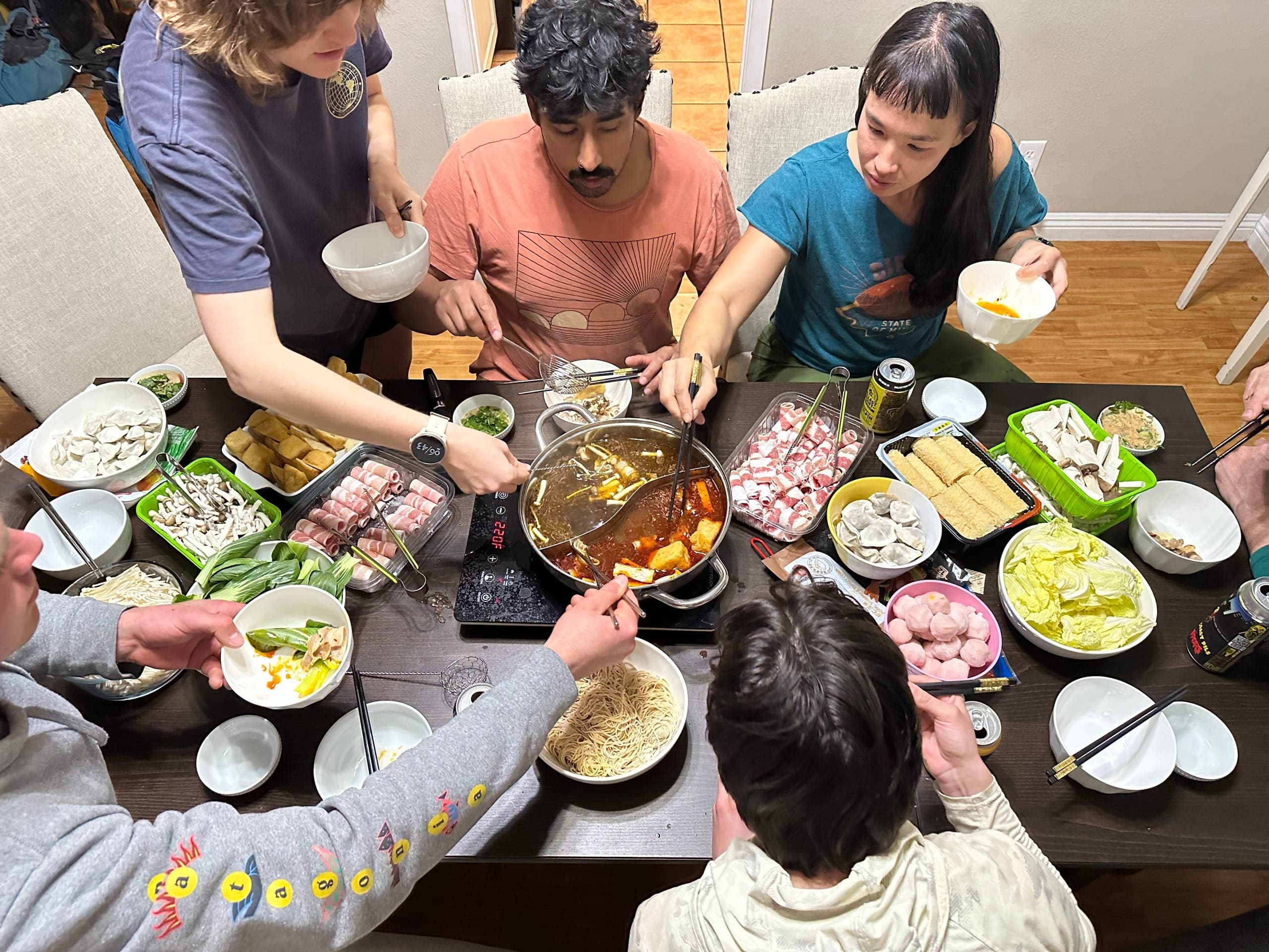 Friends gathered around a hot pot dinner